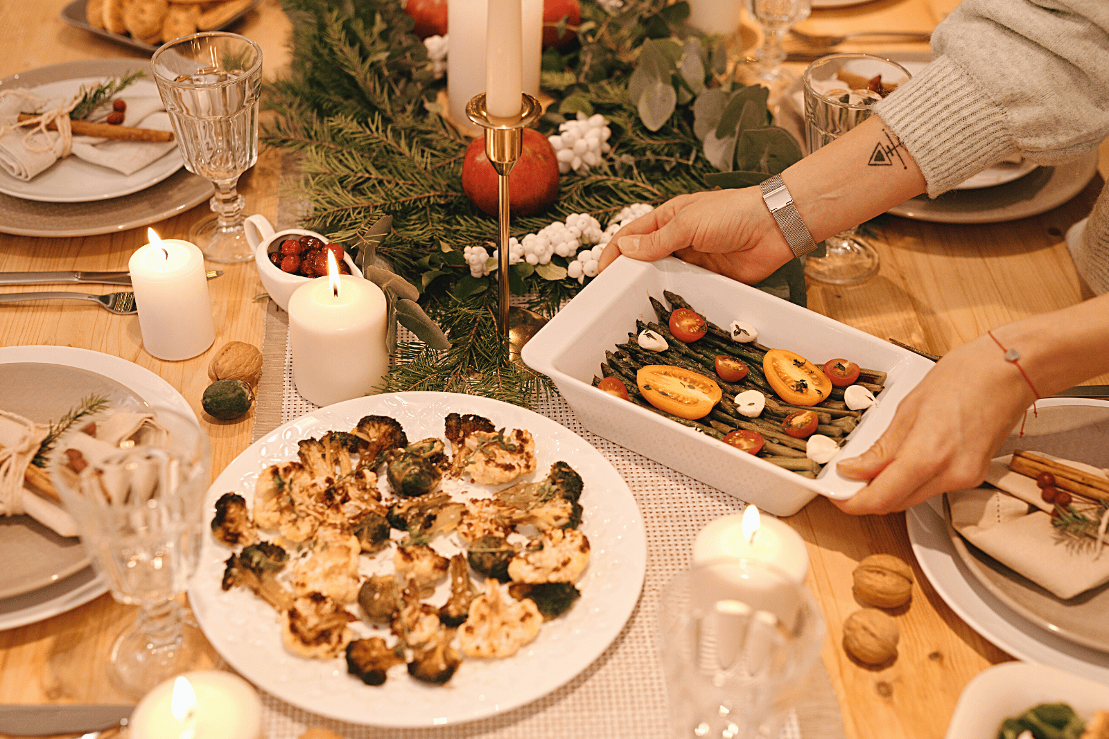 Image featuring a person arranging a dinner table with a variety of delicious food items, creating an inviting and appetizing ambiance