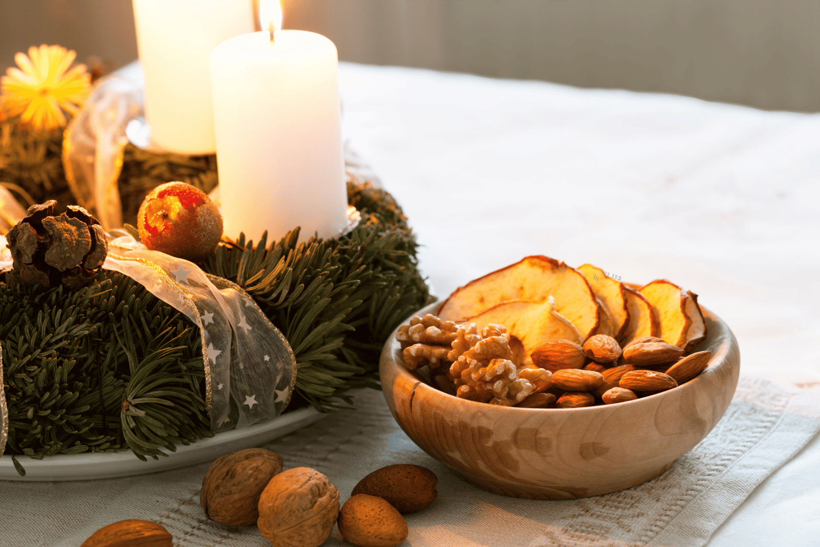 Image featuring a table adorned with a lit candle and a bowl of assorted nuts, creating a warm and inviting ambiance