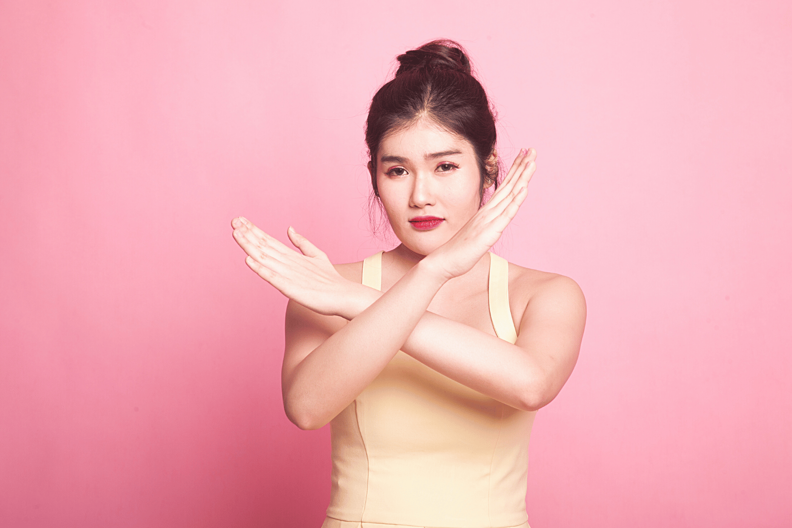 Image featuring a woman in a yellow dress gracefully gesturing a 'No', exuding elegance and poise