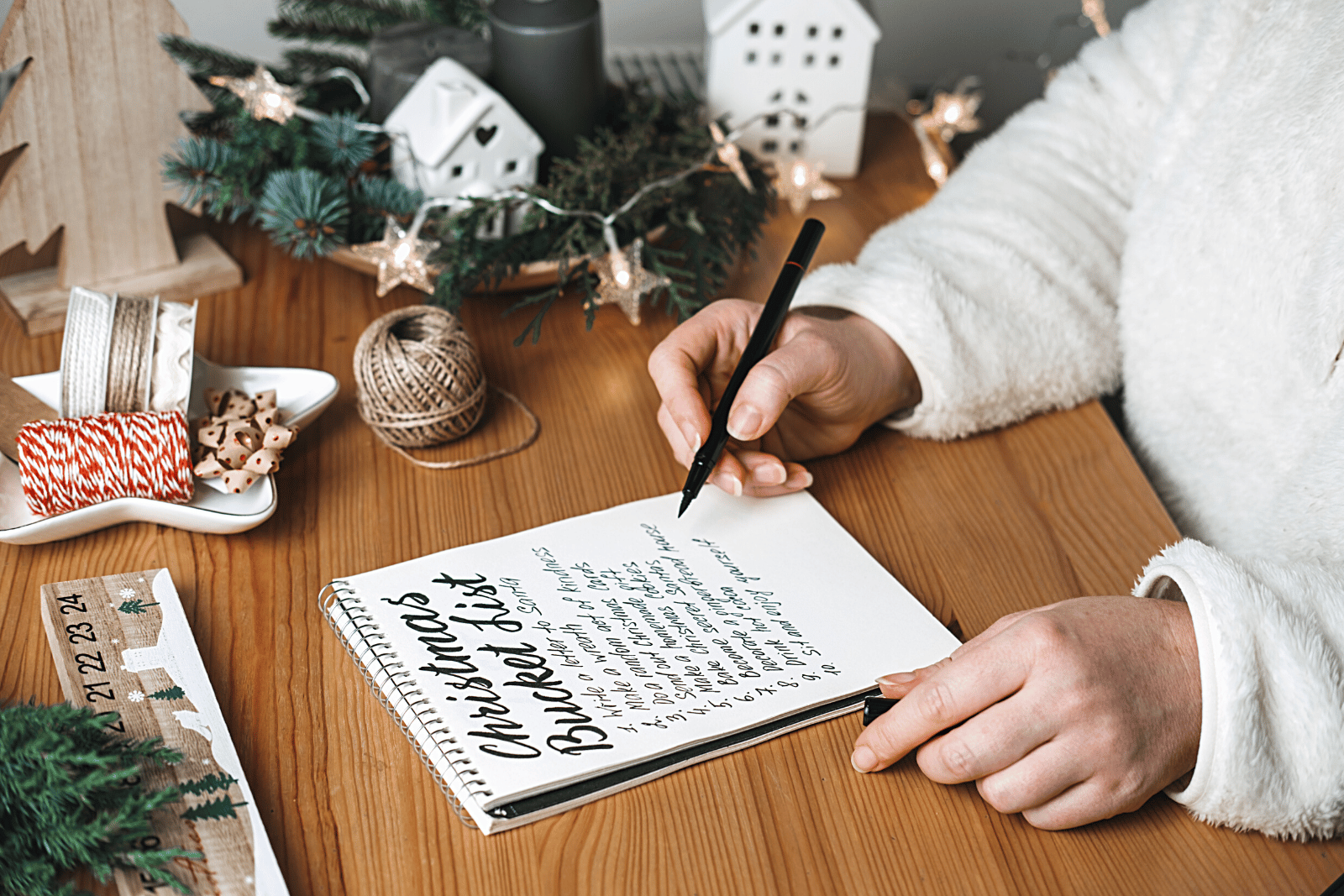 Image featuring a woman diligently planning and prioritizing Christmas tasks on a notebook, capturing the spirit of the holiday season.