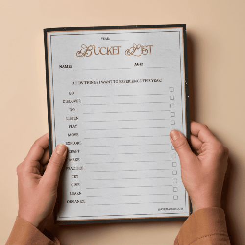 Two hands hold a blank bucket list with elegant typography, listing activities like "Go," "Explore," "Create," each with a checkbox for completion.